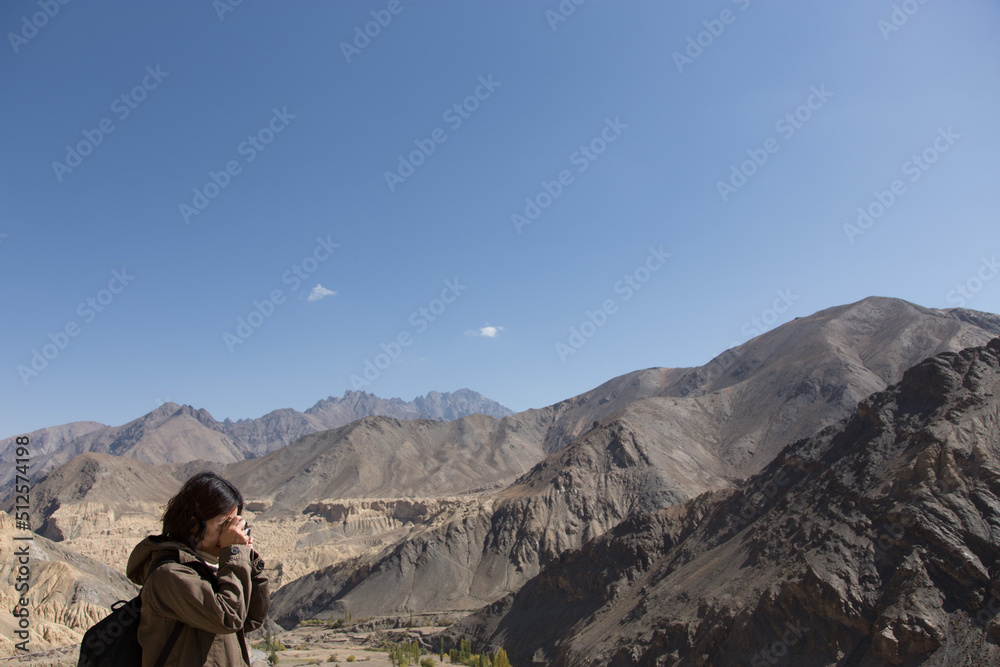 Fototapeta premium Asia woman with backpack taking photo of a beautiful mountain.