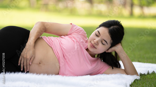 Pregnant woman touching belly in the City Park, Pregnant Relaxing and exercise, Beautiful tender mood photo of pregnancy