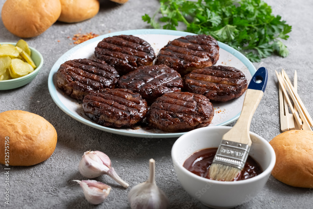 Delicious grilled cutlets and fresh buns for cooking burgers, food, outdoor eating Delicious grilled cutlets and fresh buns for cooking burgers, food, outdoor eating