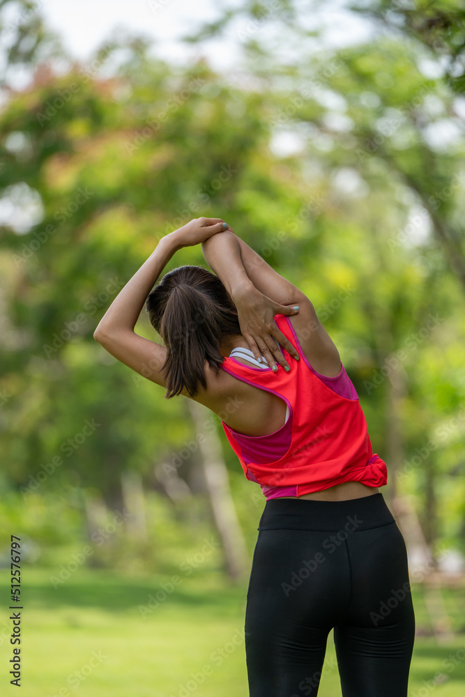 Healty Young female workout exercise before running or fitness training session in City Park. Healthy young woman warming up outdoors. She is stretching her arms at Garden park, Sports and activities Healty Young female workout exercise before running or fitness training session in City Park. Healthy young woman warming up outdoors. She is stretching her arms at Garden park, Sports and activities