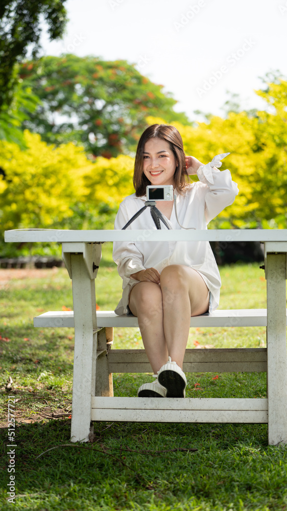 Naklejka premium Thoughtful smile Happy woman videocalling online or meeting online working with a laptop in a park