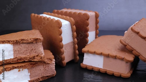 Chocolate and vanilla ice cream sandwich in cocoa biscuit on black background. Dolly shot 4k