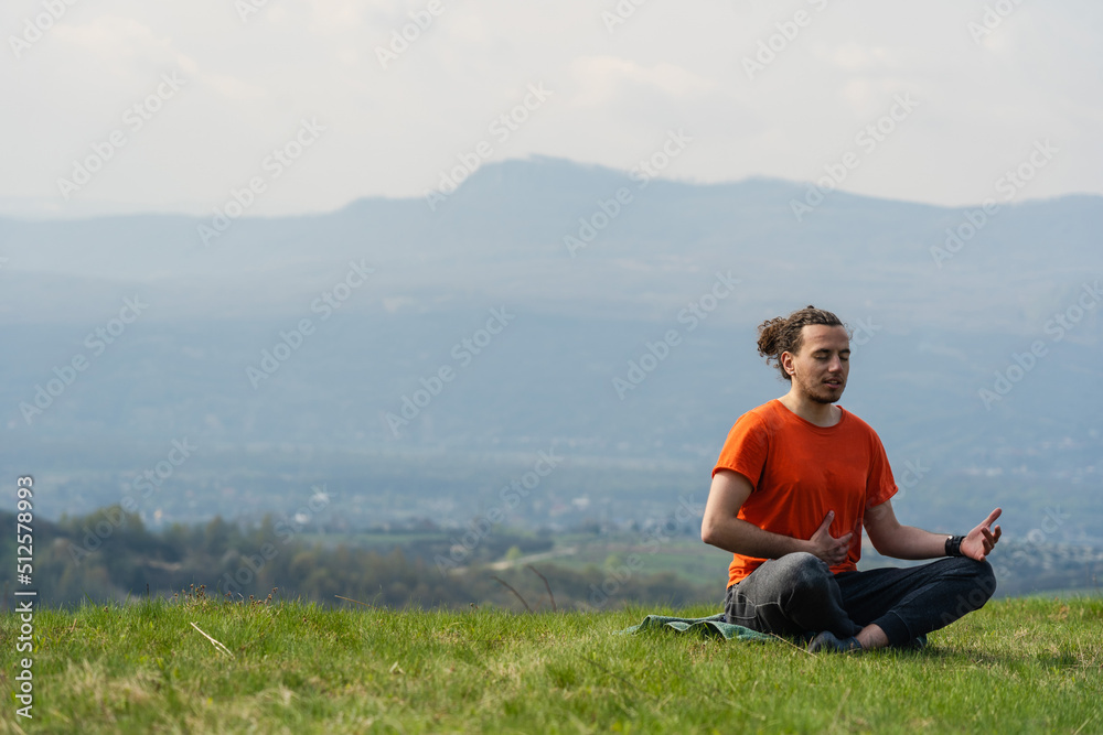 Man sitting on the mountain peak and telling something