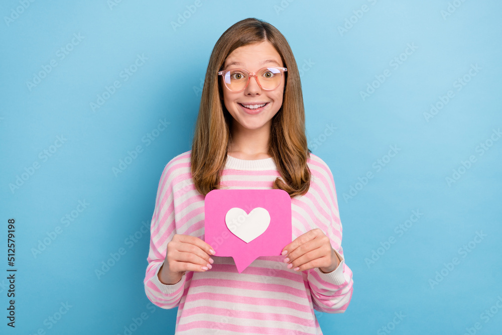 Portrait of cheerful friendly girl hold paper like card user feedback isolated on blue color background Portrait of cheerful friendly girl hold paper like card user feedback isolated on blue color background