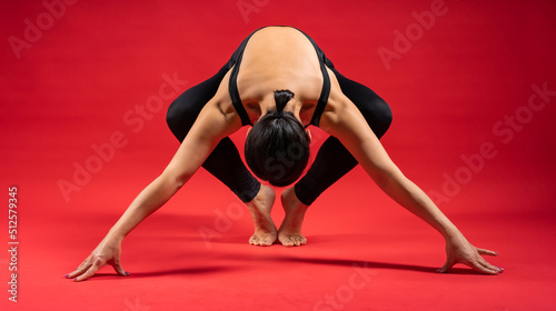 beautiful static poses. pilates on red background Woman in black sportswear. gymnastic poses