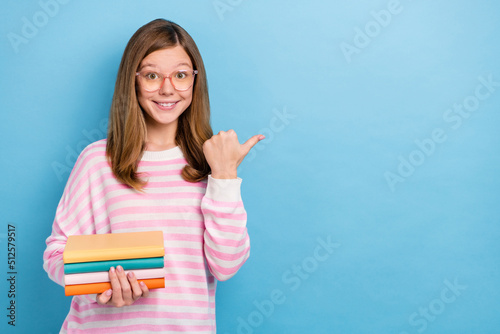Photo of friendly charming girl direct thumb finger empty space offer isolated on blue color background