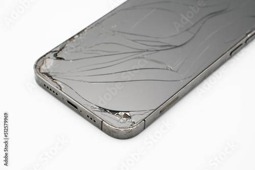 Close up of modern smartphone with broken back glass on white background.
