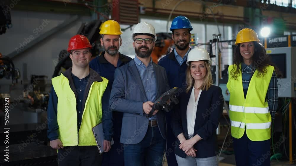 Young man worker with Down syndrome with manager and other collegues working in industrial factory, social integration concept. Young man worker with Down syndrome with manager and other collegues working in industrial factory, social integration concept.
