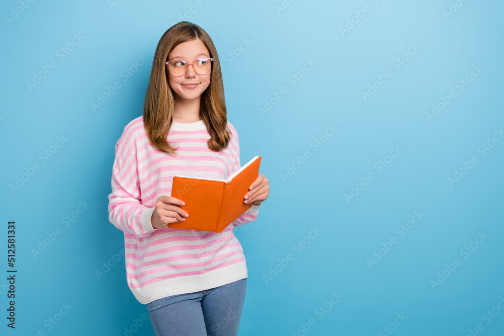Photo of minded intelligent person hold book look interested empty space isolated on blue color background Photo of minded intelligent person hold book look interested empty space isolated on blue color background