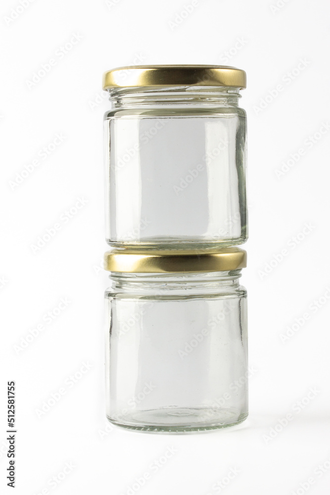 Two transparent glass jar for pickle and sauces on white background Two transparent glass jar for pickle and sauces on white background