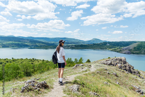 Young beautiful woman walking outdoor in the nature above a lake 