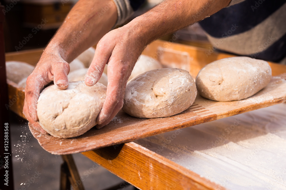 wheat dough shaped into loaves arranged in rows on the table before baking wheat dough shaped into loaves arranged in rows on the table before baking