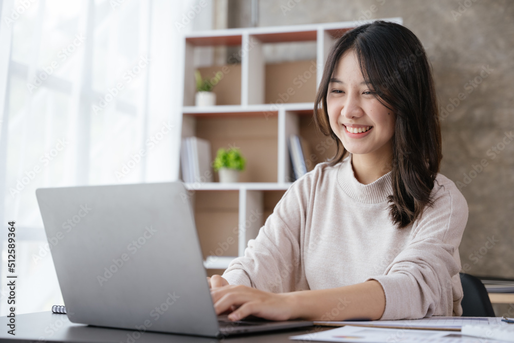 Young business women working and typing on laptop with happy and smile face on office spec.