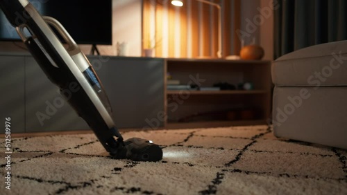 Unrecognizable an vacuum cleaning carpet in living room, lowsection close-up photo