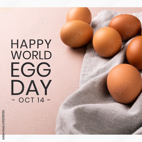 Composite of brown eggs with napkin and happy world egg day with oct 14th text on pink background