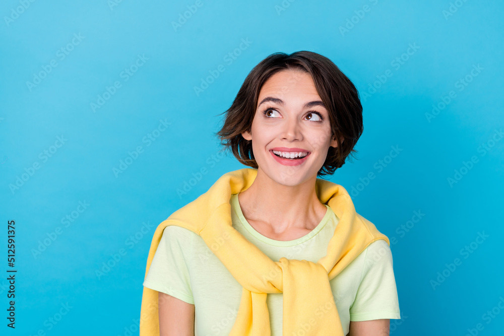 Fototapeta premium Photo of impressed young brunette lady look empty space wear yellow t-shirt isolated on blue color background