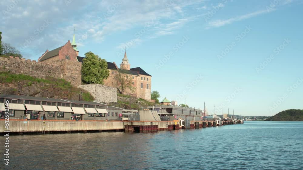 A panoramic view time lapse of the fjord in Oslo with a castle sitting in the background in front of a blue hill. A panoramic view time lapse of the fjord in Oslo with a castle sitting in the background in front of a blue hill.