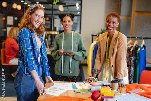 Portrait of happy multiracial female fashion designers working in creative office photo