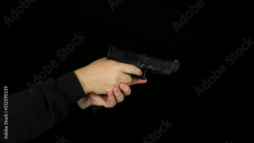 Side view of a man cocking and firing a hand gun pistol