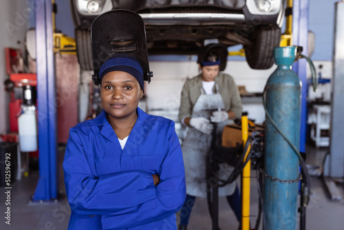 Portrait of confident mid adult female african american welder wearing protective workwear photo