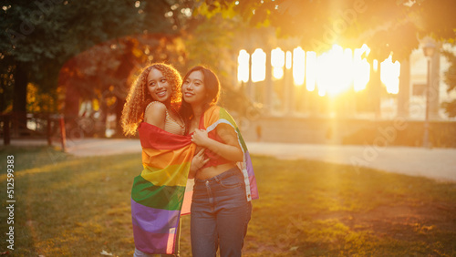 Same sex couple with pride flag in sunset