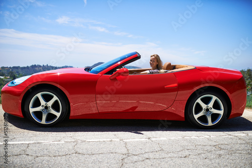 Yep, shes fast. Shot of a young woman driving in a sports car.