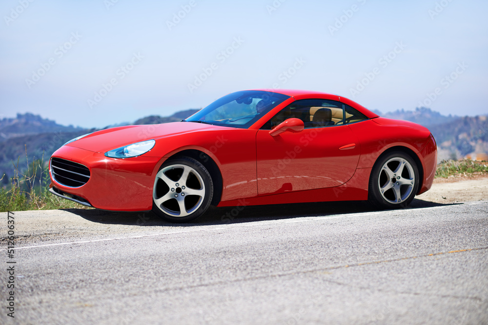 Red cars go faster. Shot of a young woman driving in a sports car.