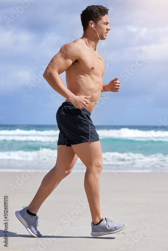 Take your workout one step at a time. Shot of a handsome young man jogging on the beach.