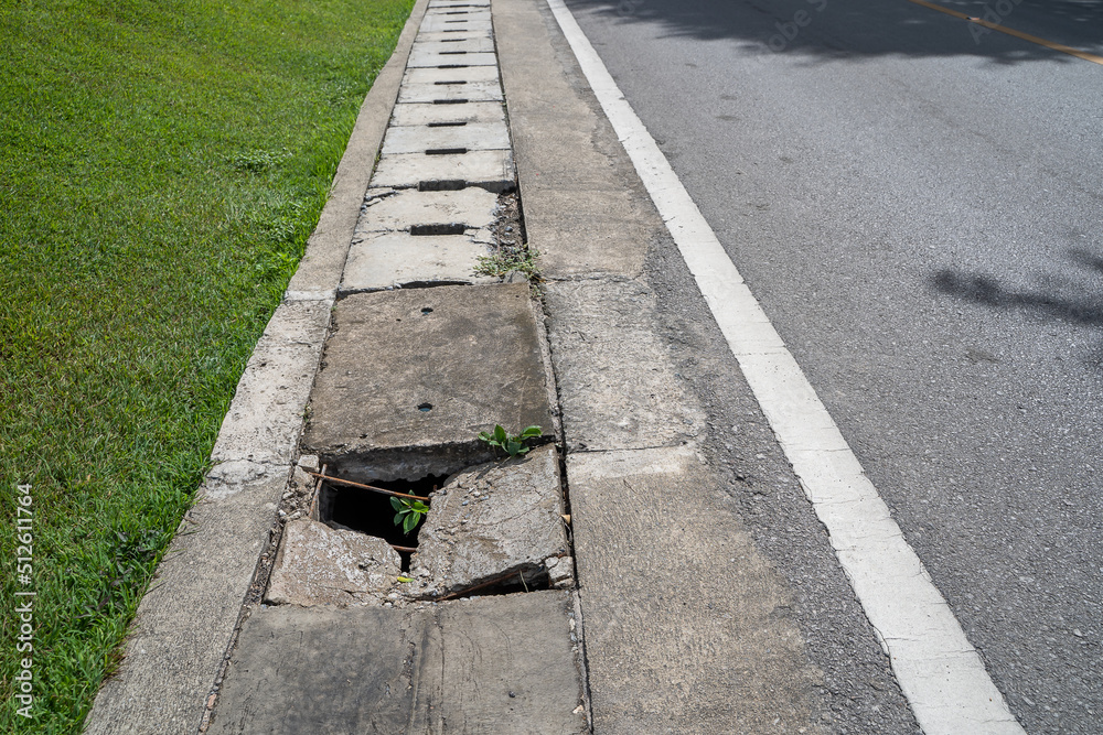 Obraz premium Damage manhole cover footpath and road. Manhole cement damage on street urban city. Damage cement gutter cover dangerous place at the town.