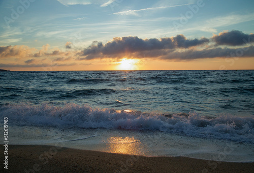 Amazing beach sunset with incredible foamy waves and cirrus clouds above the sea. Natural dawn background. 