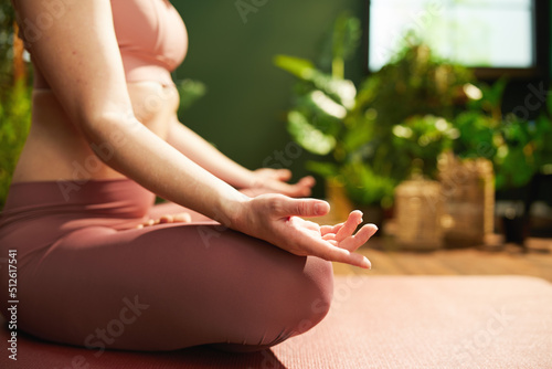 Modern 30 years old woman at green home meditating