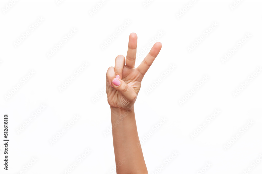 Naklejka premium A female hand with a delicate pink manicure showing a peace gesture isolated on a white background. Victory hand sign