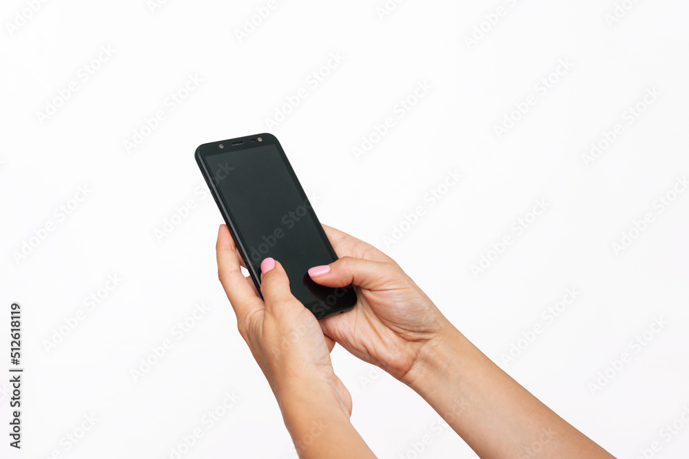 Mobile phone with black screen in female hands isolated on a white background. Blank with an empty copy space for the text. Template for the design. Mockup of a smartphone. A young woman using phone Mobile phone with black screen in female hands isolated on a white background. Blank with an empty copy space for the text. Template for the design. Mockup of a smartphone. A young woman using phone