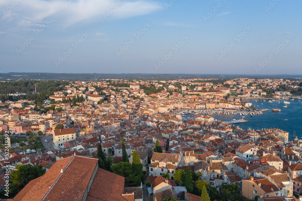 Aerial view of the old city of Rpvinj by sunset with the city harbor in the background, Croatia