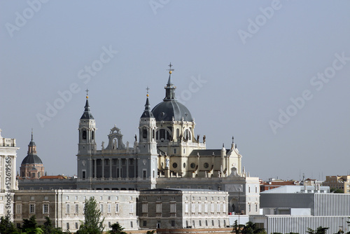 The upper part Almudena Cathedral rising above a wing of the Royal Palace. View from Parque del Oeste, Madrid Spain.