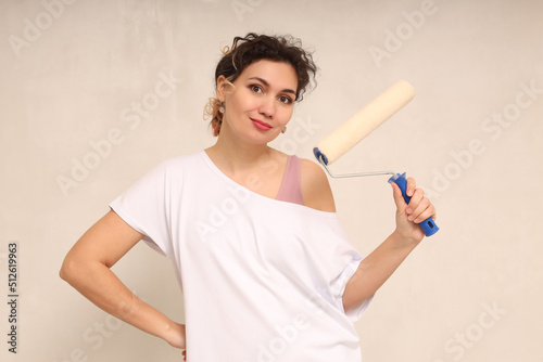 Happy beautiful young woman holding a roller