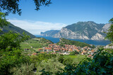 view of Lake Garda and the village of Nago, vineyards and mountains on a sunny summer morning