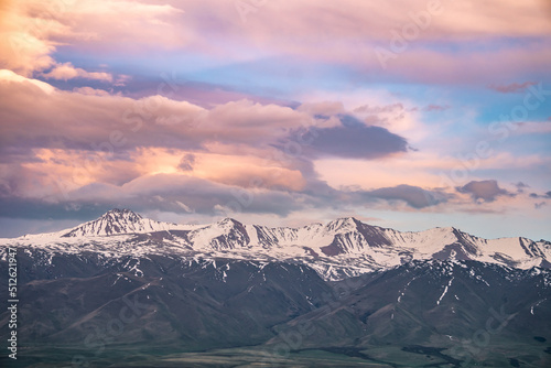 Sunset in the mountains, clouds and snowy peaks, slopes of the Tien Shan mountains, Suusamyr, Kyrgyzstan