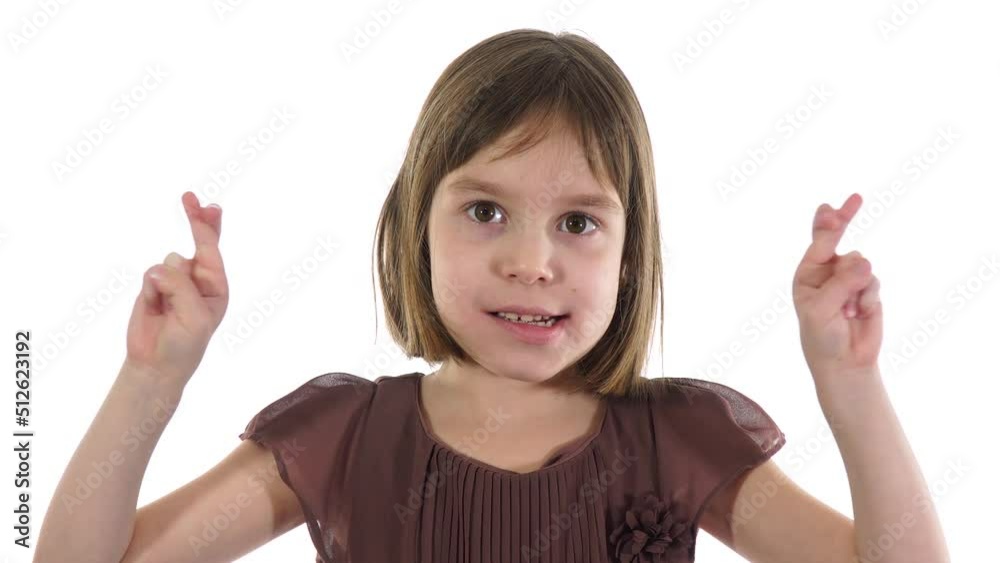 Blonde caucasian girl 6-7 years, crossing her fingers when she hoping for good luck. Fingers crossed hand, gesture. White background. Blonde caucasian girl 6-7 years, crossing her fingers when she hoping for good luck. Fingers crossed hand, gesture. White background.