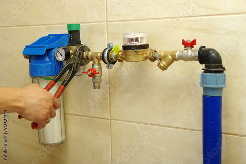 Fotografie Plumber installing water equipment - meter, filter and pressure reducer