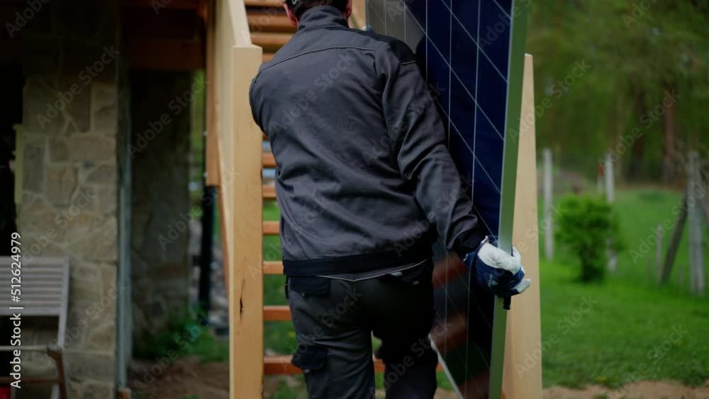 Man worker carrying solar panel for installing solar modul system on house.