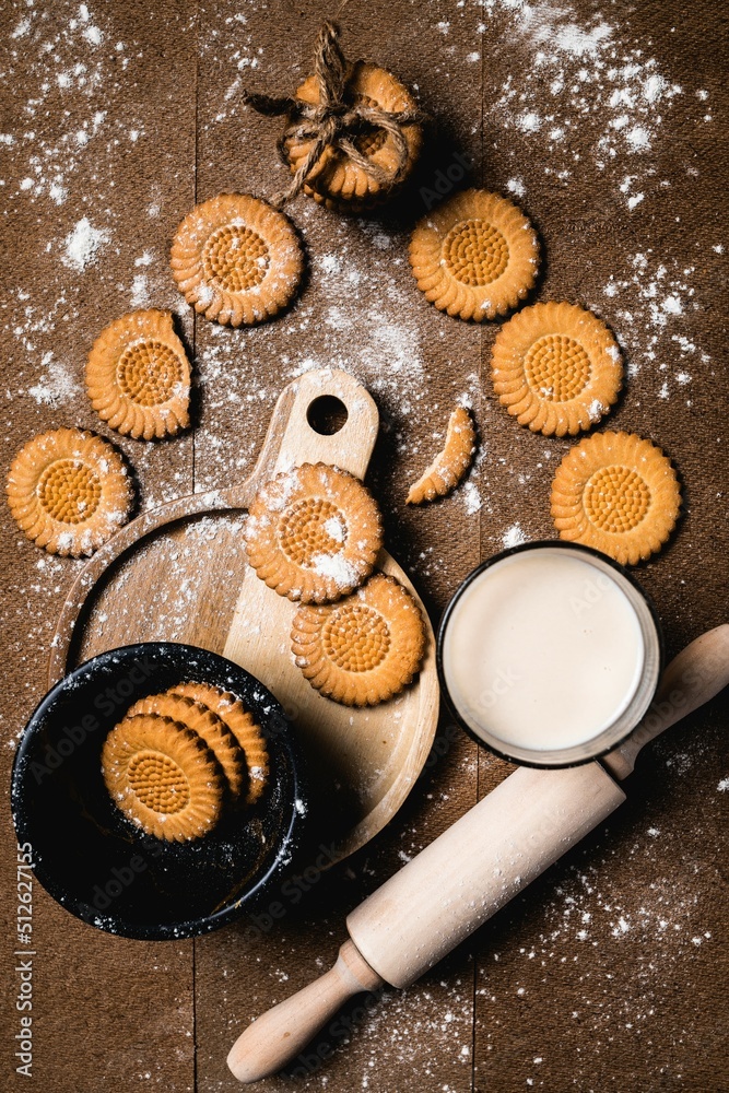 Galletas atadas en hilo con un fondo de un vaso de leche. Concepto de bebidas, alimentos y snacks Galletas atadas en hilo con un fondo de un vaso de leche. Concepto de bebidas, alimentos y snacks