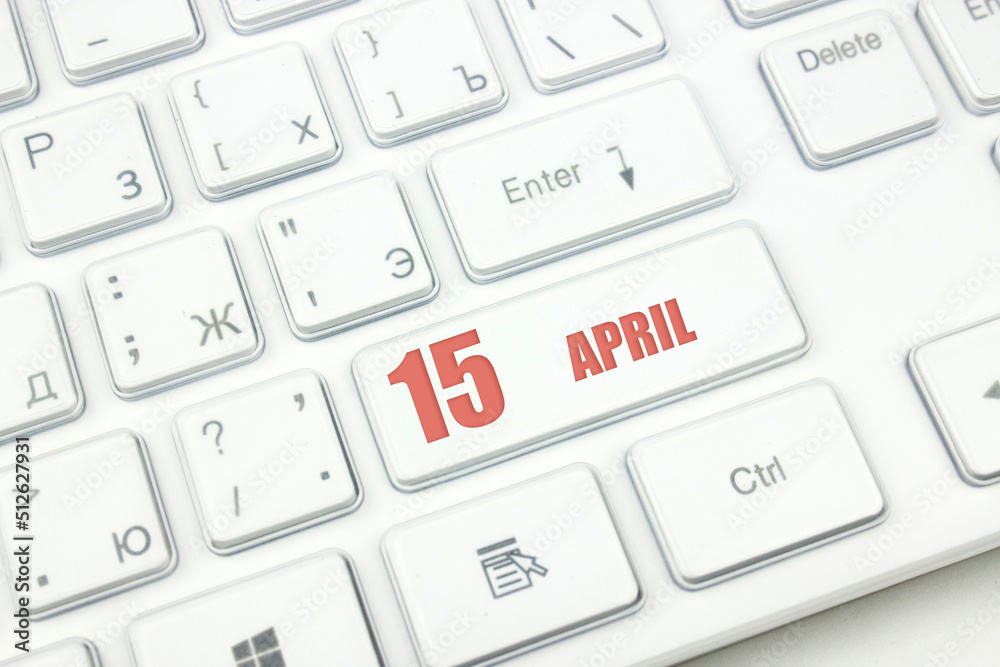 April 15th. Day 15 of month, Calendar date. Cropped view of Modern White Computer Keyboard with calendar date. Concept workspace, freelance, deadline. Spring month, day of the year concept. April 15th. Day 15 of month, Calendar date. Cropped view of Modern White Computer Keyboard with calendar date. Concept workspace, freelance, deadline. Spring month, day of the year concept.