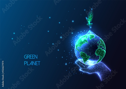 Concept of environmental social responsibility with hand holding Earth globe and sprout on dark blue photo