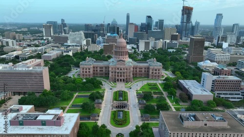 Dramatic aerial flight over dome and statue reveals downtown urban Austin Texas cityscape. TX Capitol home of state government. photo