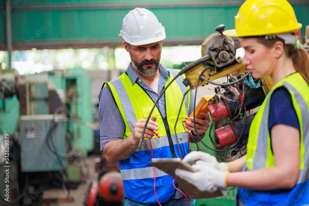 Service and maintenance concept. Service manager male engineer explain the procedure for using the correct metal robot machine at lathe industrial factory.