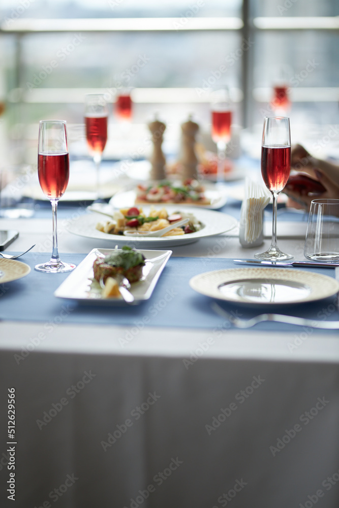 The table is set. Red wine in glasses on the table. Festive table setting  