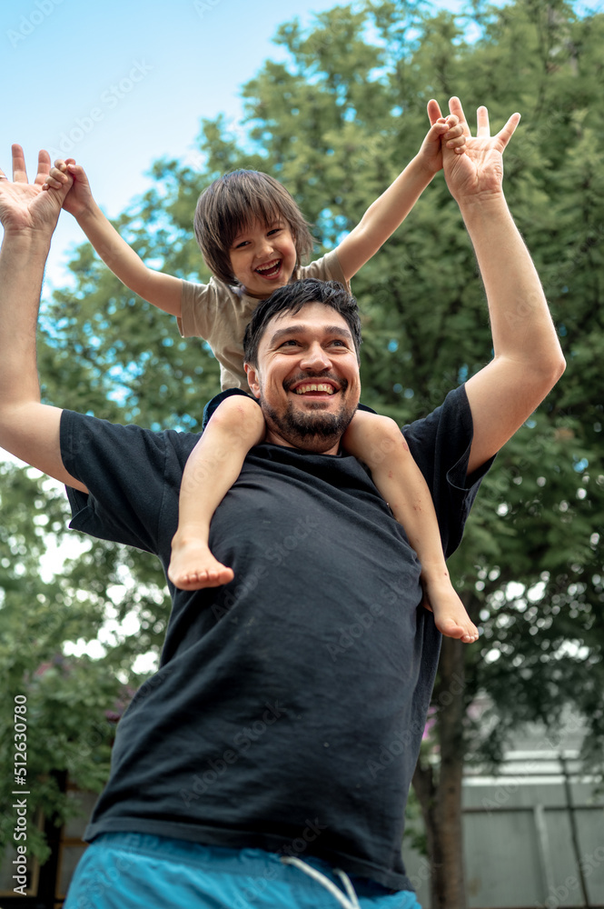 a happy, laughing baby sits on dad's shoulders, they dance and have fun. A father spends time with his son. The concept of a happy family
a happy, laughing baby sits on dad's shoulders, they dance and have fun. A father spends time with his son. The concept of a happy family
