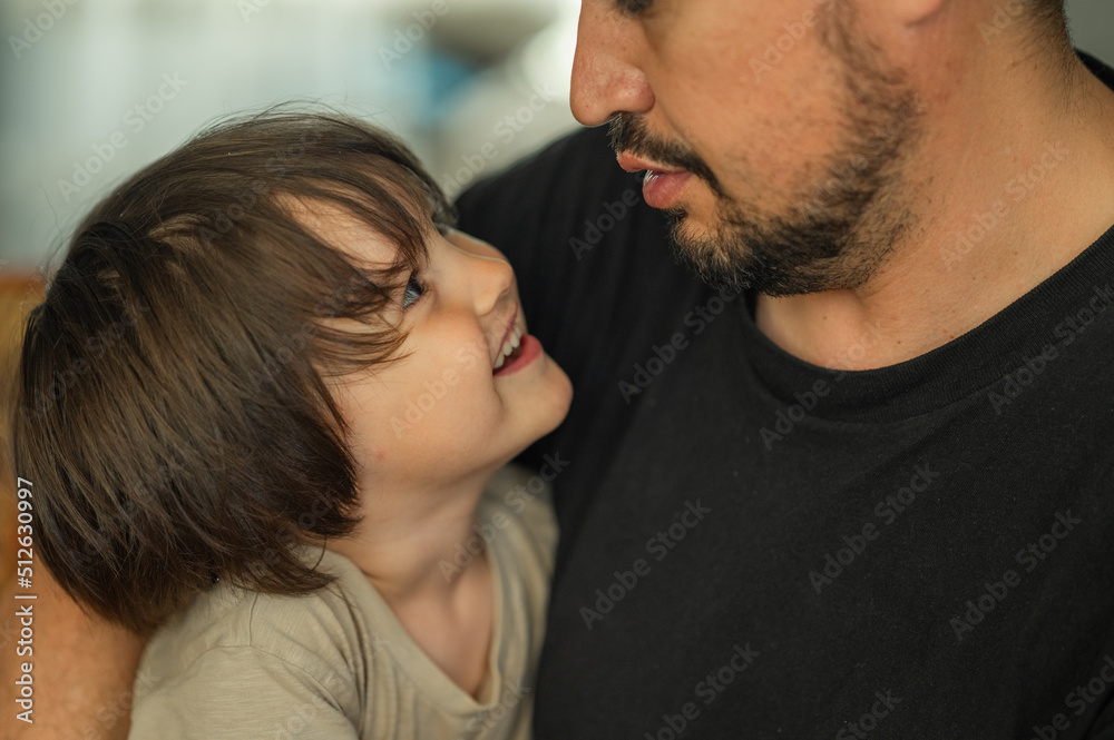 the faces of the father and son are close-up, the father spends time with his son, he talks to him, they laugh and smile, the concept of a happy family