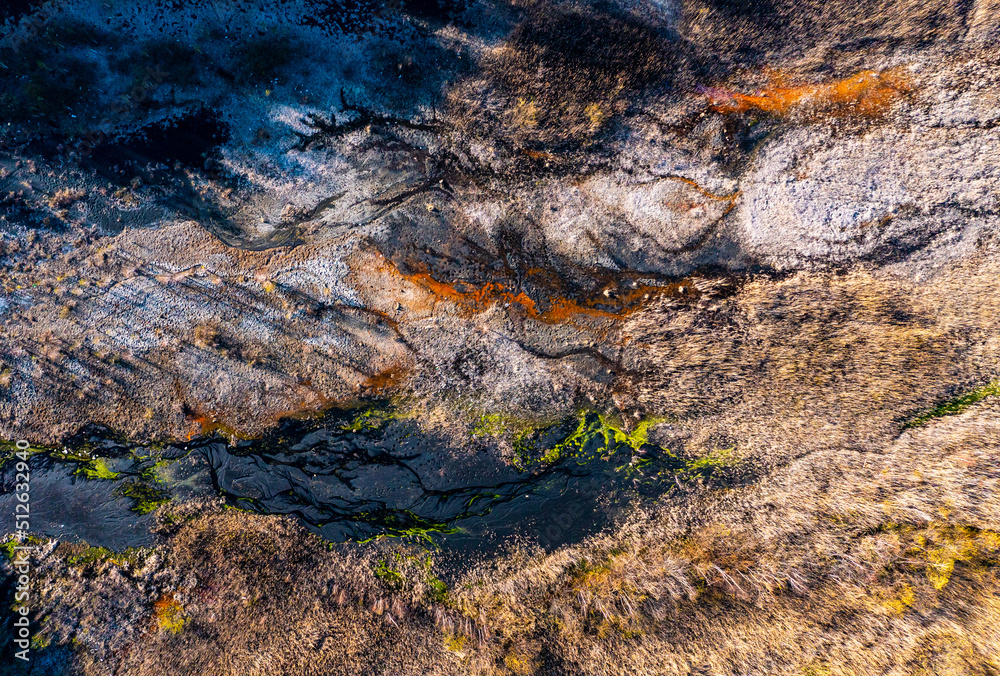 Polluted rusty dirty creek. Nature pollution concept. Water with pieces of ice around the edges. Top view of the yellow stream Polluted rusty dirty creek. Nature pollution concept. Water with pieces of ice around the edges. Top view of the yellow stream